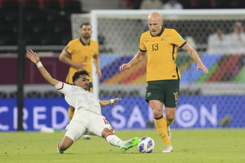 /e13/, left, and Australia's Aaron Mooy fight for the ball during a qualifying match between United Arab Emirates and Australia in Al Rayyan, Qatar, Tuesday, June 7 2022. (AP Photo/Hussein Sayed)