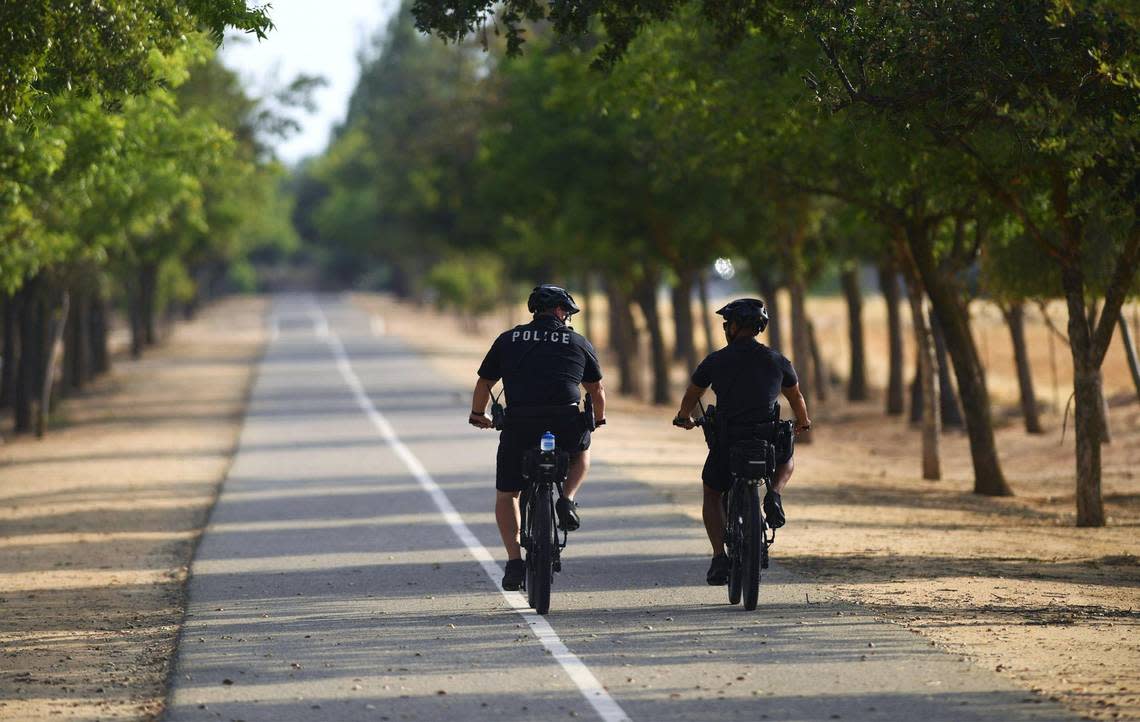 Fresno police officers Dustin Freeman, left, and Luke Tran, right, ride the Fresno-Clovis Rail Trail to River Park Saturday afternoon, July 30, 2022 in Fresno.