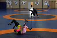 Guinean wrestler Fatoumata Yarie Camara, right, competes with Italian athlete Morena De Vita during her morning training session at the Ostia's Olympic training center, near Rome, Monday, July 5, 2021. A West African wrestler's dream of competing in the Olympics has come down to a plane ticket. Fatoumata Yarie Camara is the only Guinean athlete to qualify for these Games. She was ready for Tokyo, but confusion over travel reigned for weeks. The 25-year-old and her family can't afford it. Guinean officials promised a ticket, but at the last minute announced a withdrawal from the Olympics over COVID-19 concerns. Under international pressure, Guinea reversed its decision. (AP Photo/Alessandra Tarantino)