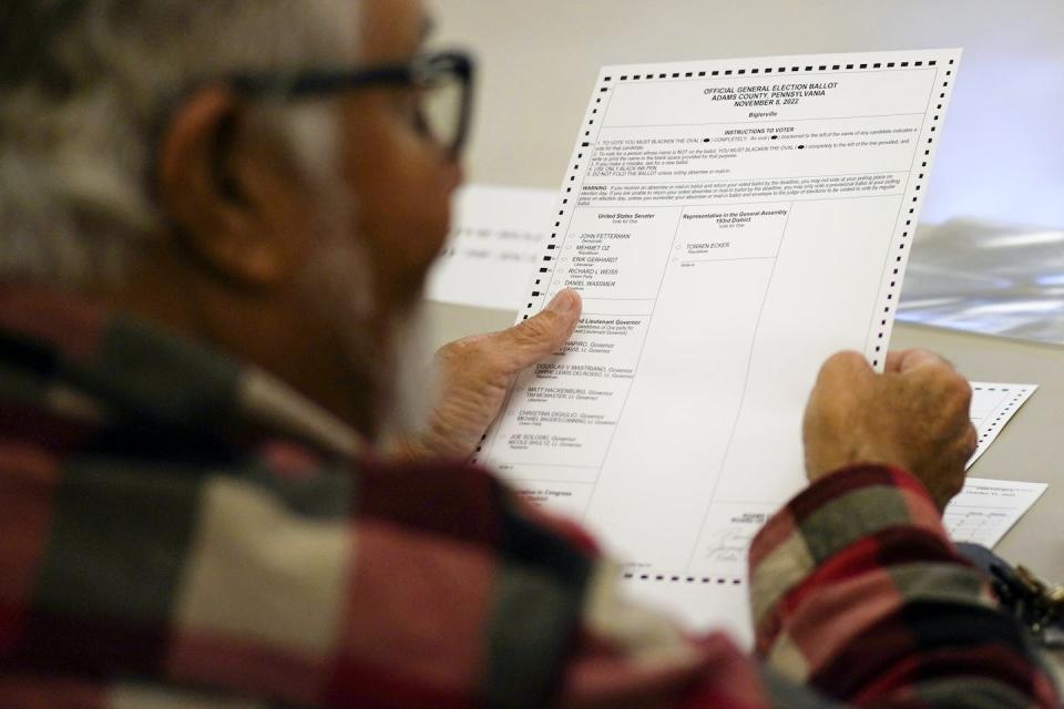 A poll worker holds a ballot at the Trinity Christian Fellowship Hall polling place in Biglerville, Pa., on Nov. 8, 2022. <a href="https://newsroom.ap.org/detail/Election2022Pennsylvania/180321d9407f44729a96ee63a2b5b7f2/photo?Query=polling%20place&mediaType=photo&sortBy=arrivaldatetime:desc&dateRange=&totalCount=113&currentItemNo=29" rel="nofollow noopener" target="_blank" data-ylk="slk:AP Photo/Carolyn Kaster;elm:context_link;itc:0;sec:content-canvas" class="link ">AP Photo/Carolyn Kaster</a>