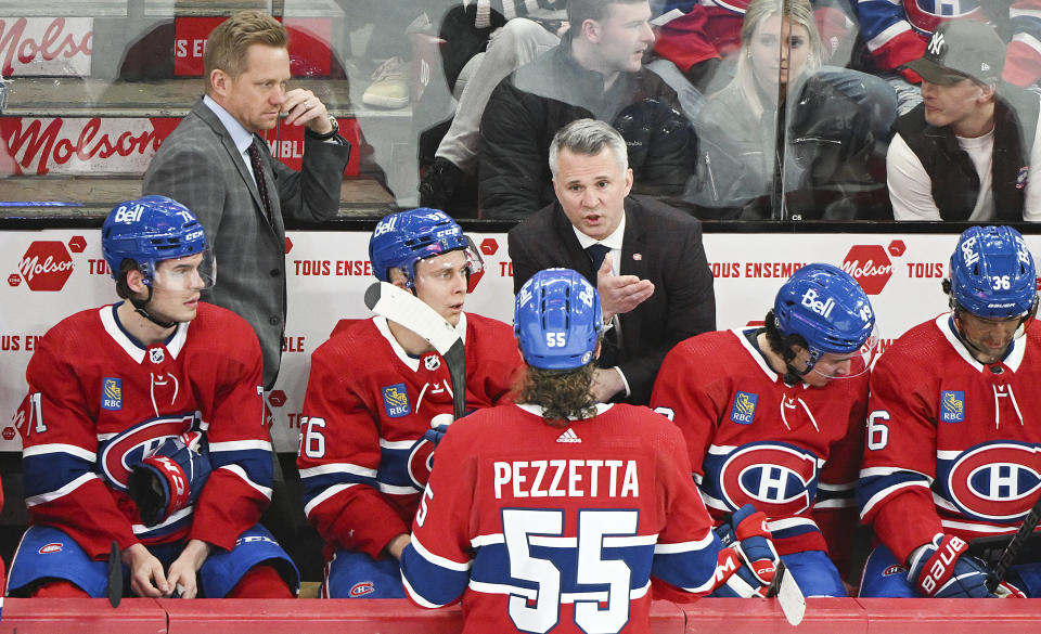 Montreal Canadiens head coach Martin St-Louis, center, talks to players as assistant coach Trevor Letowski, left, looks on during the first period of an NHL hockey game against the Carolina Hurricanes in Montreal, Quebec, Saturday, March 30, 2024. (Graham Hughes/The Canadian Press via AP)