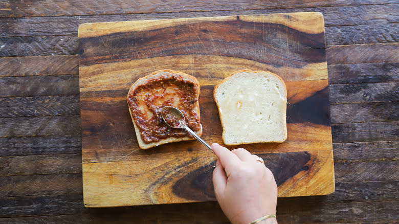 Spreading cranberry mostarda on bread