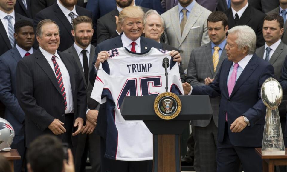 Trump holds his Patriots jersey alongside Belichick (left) and team owner Robert Kraft, during the team’s visit to the White House as Super Bowl champions last April.