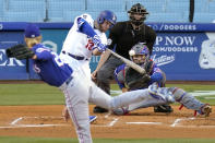Los Angeles Dodgers' Max Muncy, second from left, hits a two-run home run as Texas Rangers starting pitcher Mike Foltynewicz, left, and catcher Jose Trevino, right, watch along with home plate umpire Nic Lentz during the first inning of a baseball game Friday, June 11, 2021, in Los Angeles. (AP Photo/Mark J. Terrill)
