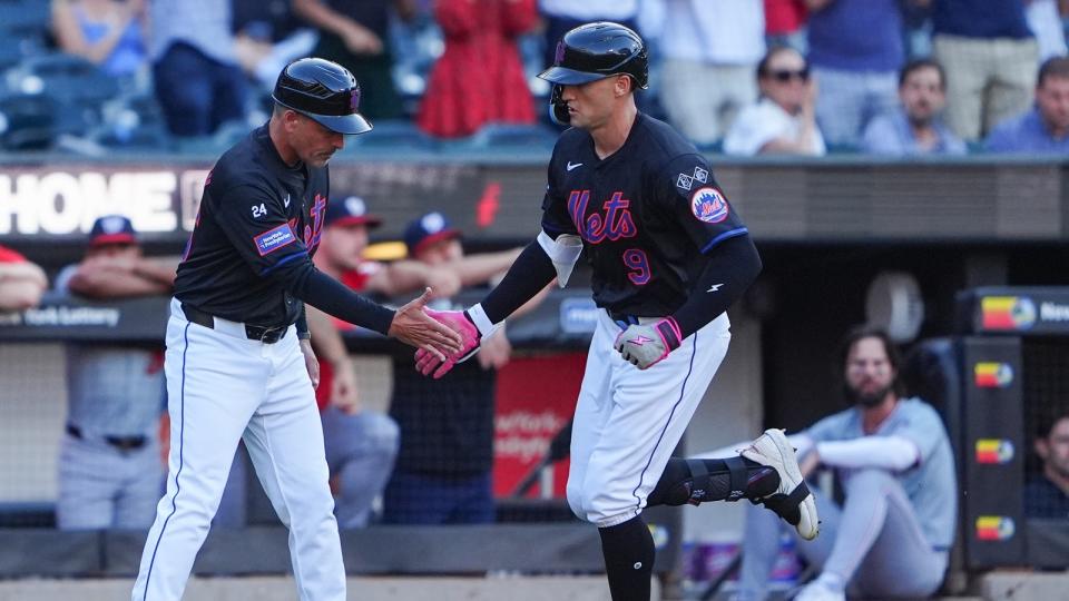 New York Mets third base coach Mike Sarbaugh (86) congratulates New York Mets left fielder Brandon Nimmo (9) for hitting a home run as he rounds the bases during the first inning at Citi Field.