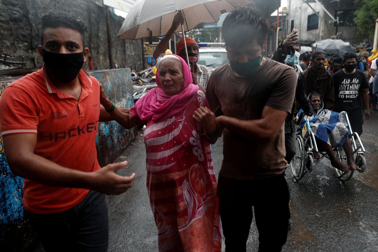 People help elderly citizens during an evacuation from a Mumbai slum: REUTERS