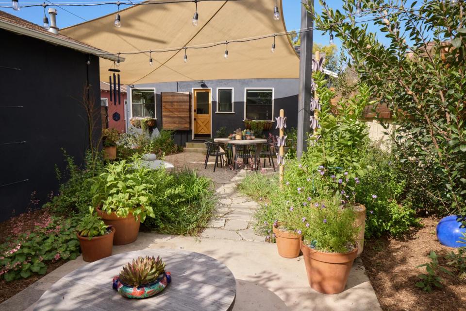 Potted plants fill a backyard patio.