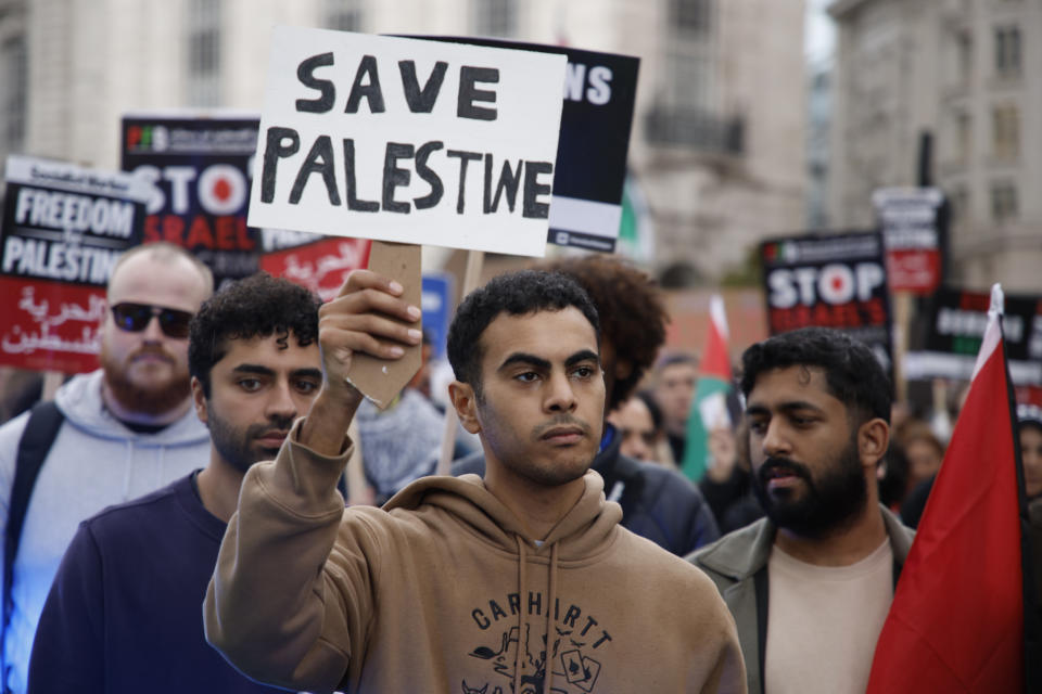 Demonstrators hold up flags and placards during a pro Palestinian demonstration in London, Saturday, Oct. 21, 2023. (AP Photo/David Cliff)