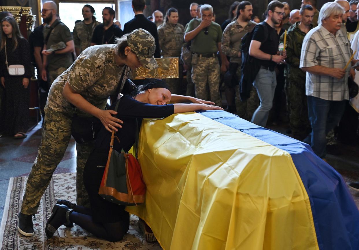 Nadiya, the mother of late Ukrainian serviceman Roman Barvinok, mourns at his coffin during a funeral service in Kyiv on August 28, 2022.