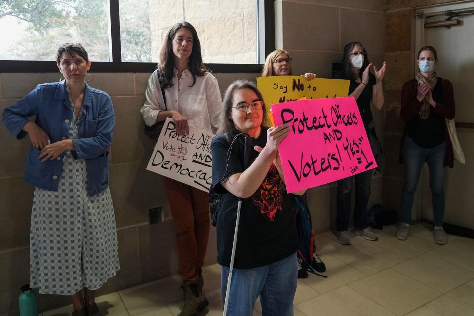 Tiffany Pagni, front, and others cheer during the Austin City Council meeting at City Hall on Wednesday.