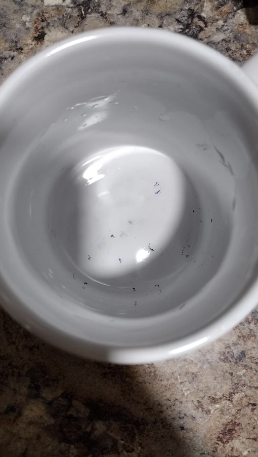 A mug with lots of ink marks at the bottom and sides