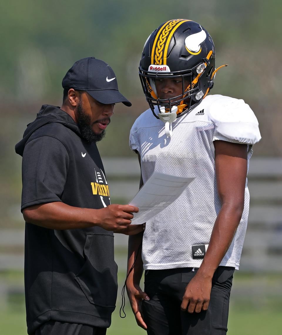 North coach DeMonte Powell, left, works with quarterback Sigmund Felding at practice on Aug. 3.