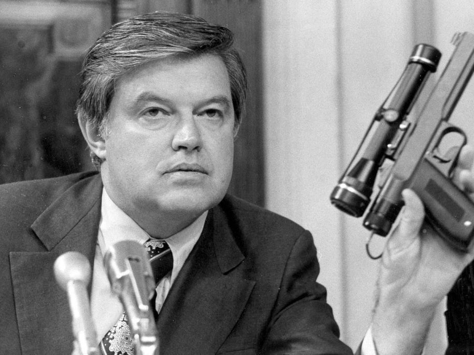 Frank Church holds up a poison dart gun