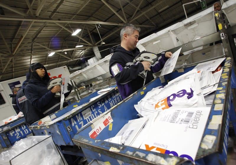 Handlers place letters and envelopes into cartons at the Marina Del Rey, California FedEx station