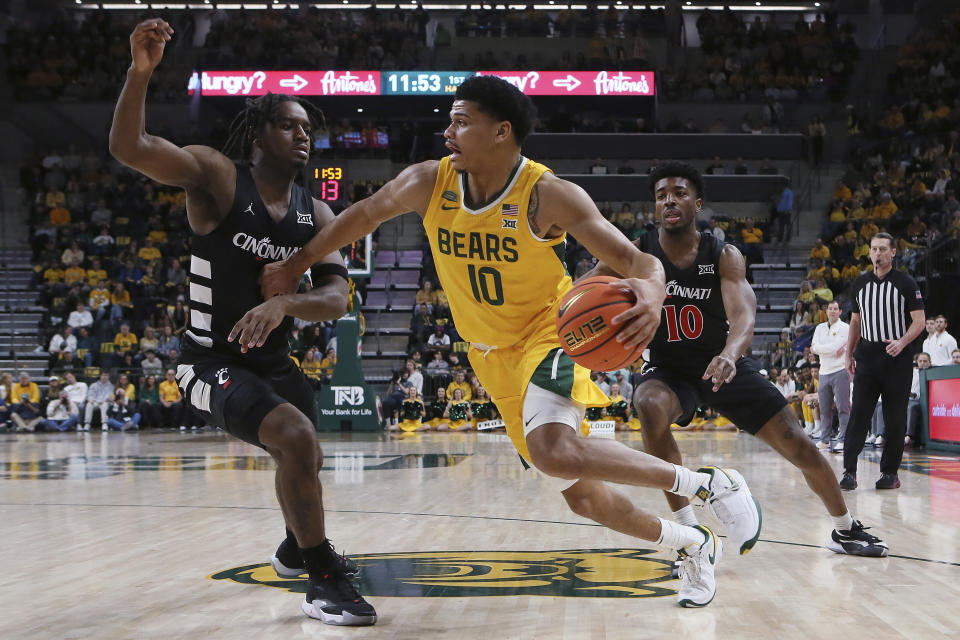 Baylor guard Ray Dennis (10) drives the ball against Cincinnati guard Jizzle James (2) during the first half of an NCAA college basketball game Saturday, Jan. 13, 2024, in Waco, Texas. (AP Photo/Jerry Larson)