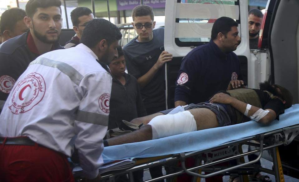 Medics move a wounded youth, who was shot by Israeli troops during a protest at the Gaza Strip's border with Israel, into the treatment room of Shifa hospital in Gaza City, Friday, May 3, 2019. Three Palestinians, including two militants, were killed by Israeli fire Friday after gunshots from the Gaza Strip wounded two Israeli soldiers, officials said, in a new flare-up that shattered a month-long easing of hostilities that was mediated by Egypt. (AP Photo/Adel Hana)