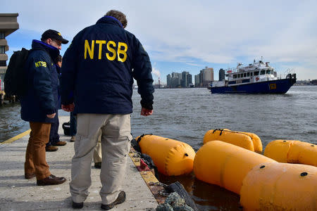 U.S. National Transportation Safety Board (NTSB) Go Team gathers information on scene while awaiting salvage of the helicopter that crashed in the East River in New York, U.S., in this image released on March 12, 2018. NTSB/Handout via REUTERS