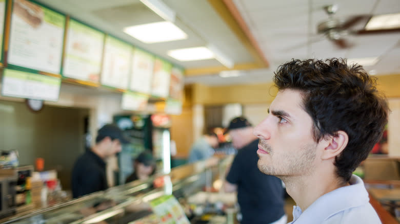 man reading fast food menu