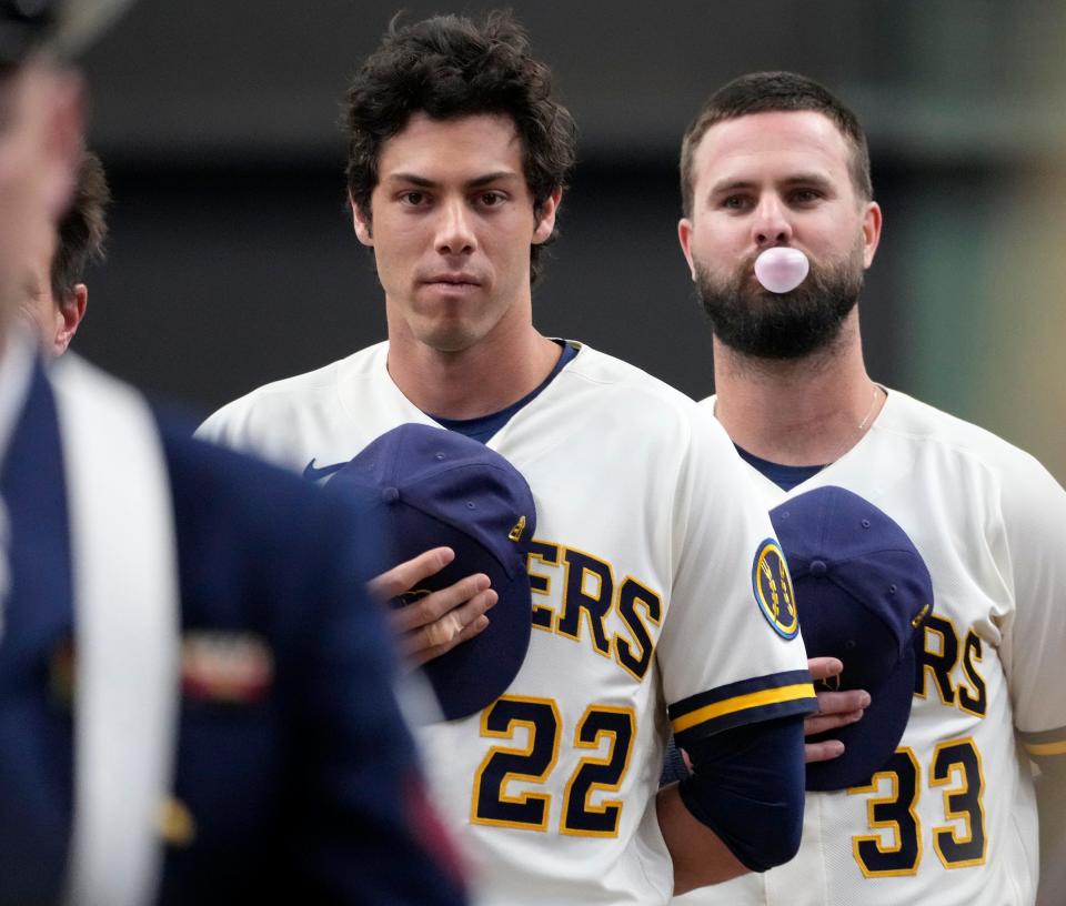 Milwaukee Brewers left fielder Christian Yelich (22) and left fielder Jesse Winker (33) wait for the national anthem to begin before the Milwaukee Brewers' home opener Monday against the New York Mets at American Family Field in Milwaukee.