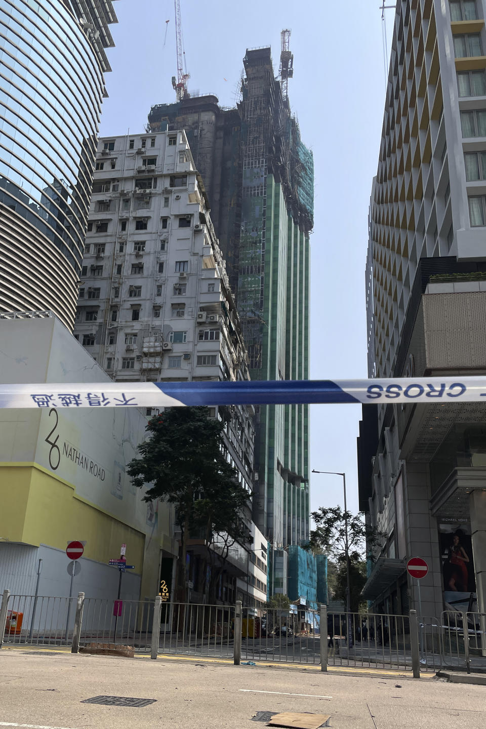 A tape cordons off the area near a high-rise construction site that caught fire overnight in Hong Kong, Friday, March 3, 2023. Hong Kong firefighters battled a blaze Friday that broke out overnight at a construction site in a popular shopping district and forced around people in nearby buildings to evacuate. (AP Photo)