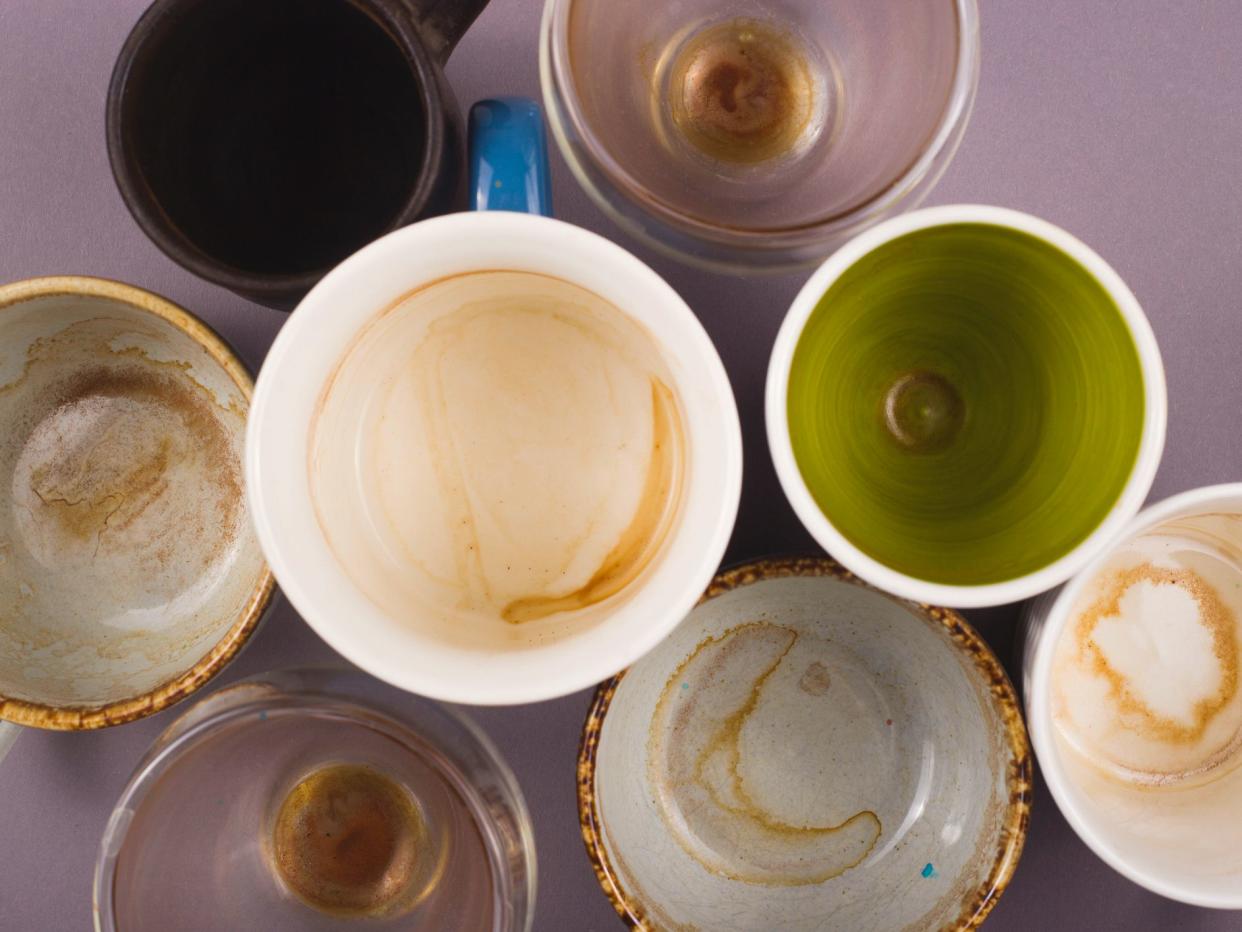 Several empty cups of coffee viewed from above on gray table. Top view layout.