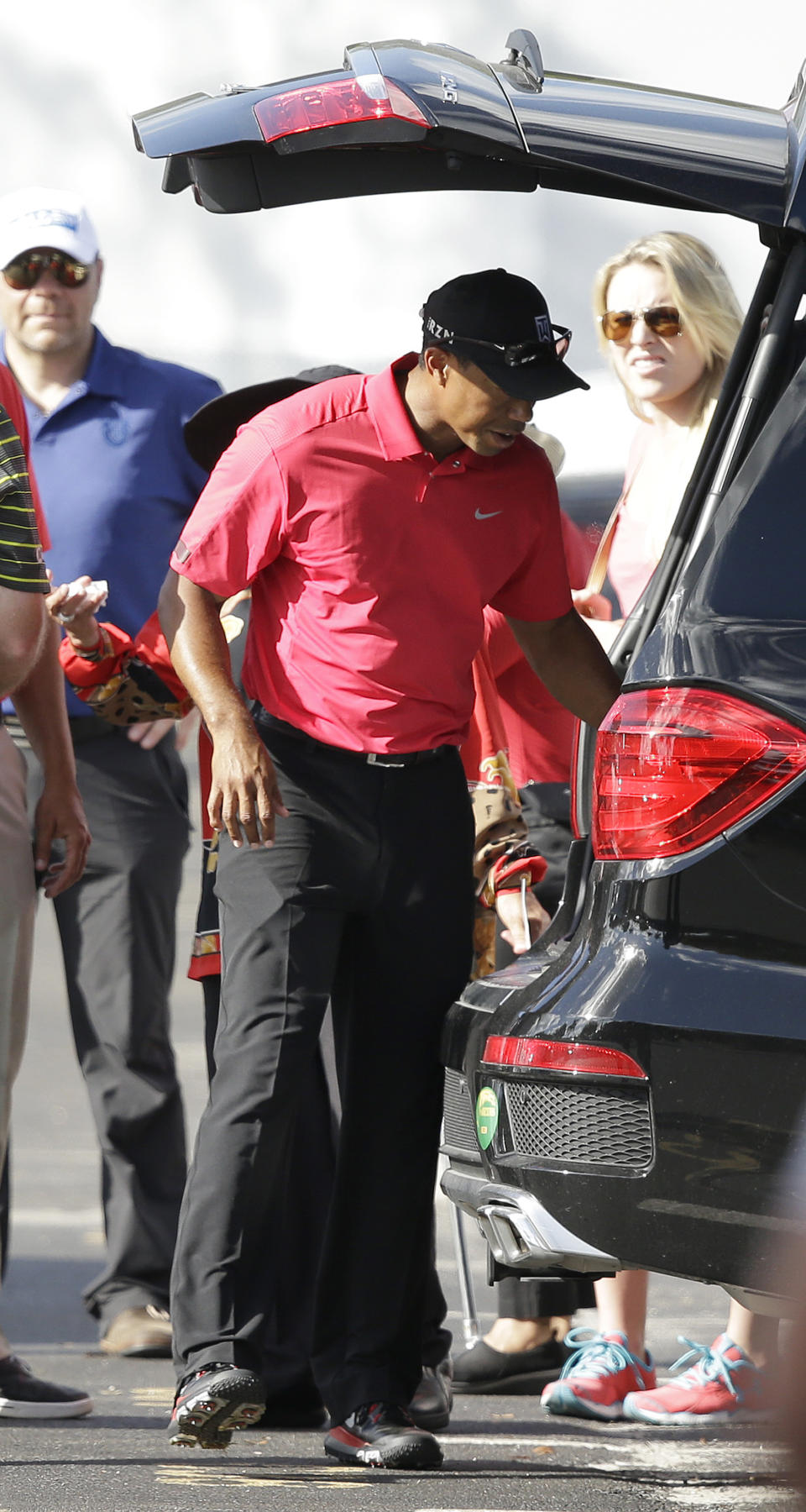 Tiger Woods loads a vehicle as he prepares to leave after withdrawing having played 13 holes in the final round of the Honda Classic golf tournament on Sunday, March 2, 2014, in Palm Beach Gardens, Fla. (AP Photo/Wilfredo Lee)