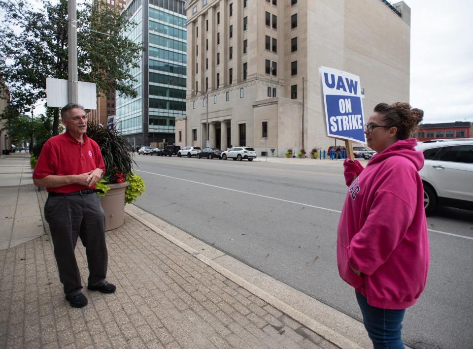 UAW Local 2256 Vice President Alan Harris, left, speaks with a picketer in front of the Blue Cross Blue Shield of Michigan Lansing office, Wednesday, Sept. 13, 2023.