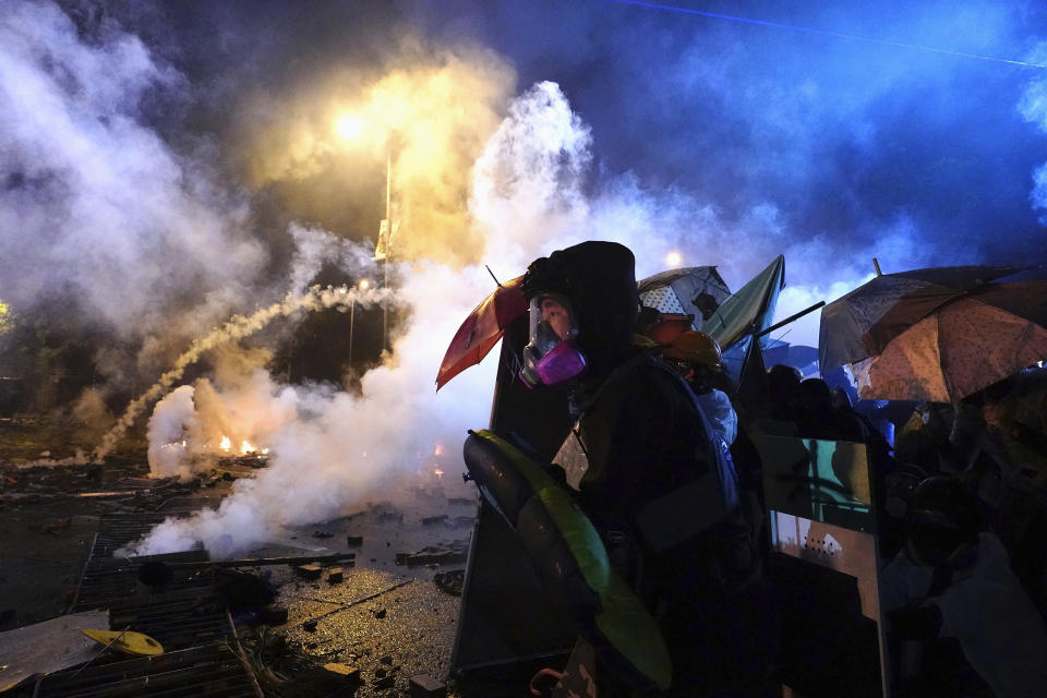 Protestors react as police fire tear gas near Hong Kong Polytechnic University after police gave protestors an ultimatum to leave the campus in Hong Kong, Sunday, Nov. 17, 2019. One year ago, a sea of humanity _ a million people by some estimates _ marched through central Hong Kong on a steamy afternoon. It was the start of what would grow into the longest-lasting and most violent anti-government movement the city has seen since its return to China in 1997. (AP Photo/Vincent Yu, File)