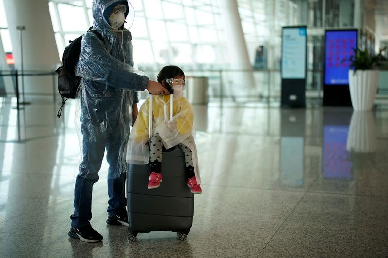 People wearing protective gear are seen at the Wuhan Tianhe International Airport