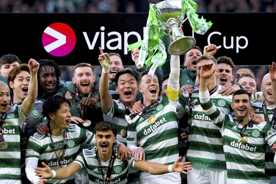 Celtic's Callum McGregor celebrates with the trophy after winning the Scottish League Cup Final at Hampden Park, Glasgow, Scotland, Sunday Feb. 26, 2023. (Andrew Milligan/PA via AP)