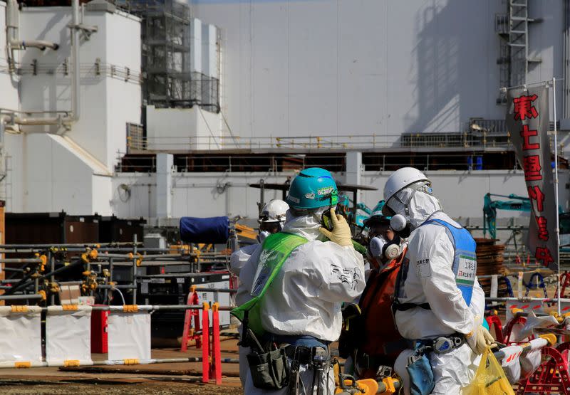 A worker talks on the phone near No. 3 reactor building at the tsunami-crippled Fukushima Daiichi nuclear power plant in Okuma town, Fukushima prefecture