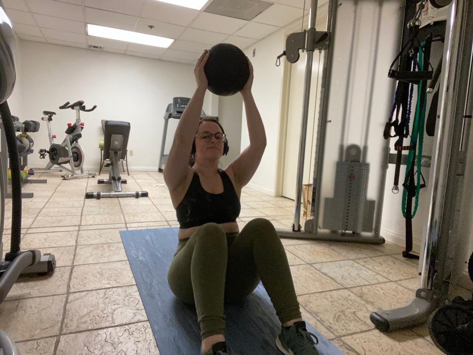 Freelancer Paige Bennett lifting a weighted ball.
