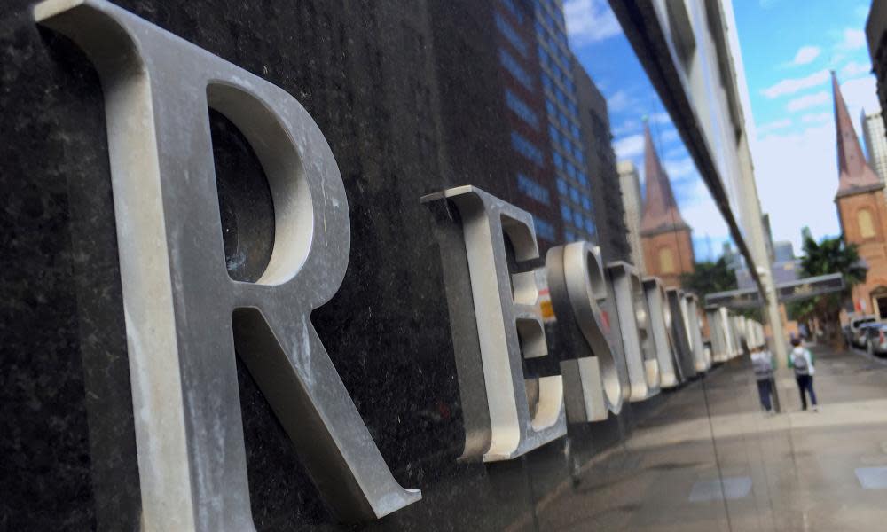 A pedestrian is reflected in a wall of the Reserve Bank of Australia head office in central Sydney