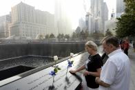 A couple pauses pauses along the edge of the North Pool of the 9/11 Memorial during a ceremony marking the 12th anniversary of the 9/11 attacks on the World Trade Center in New York September 11, 2013. (REUTERS/Justin Lane)