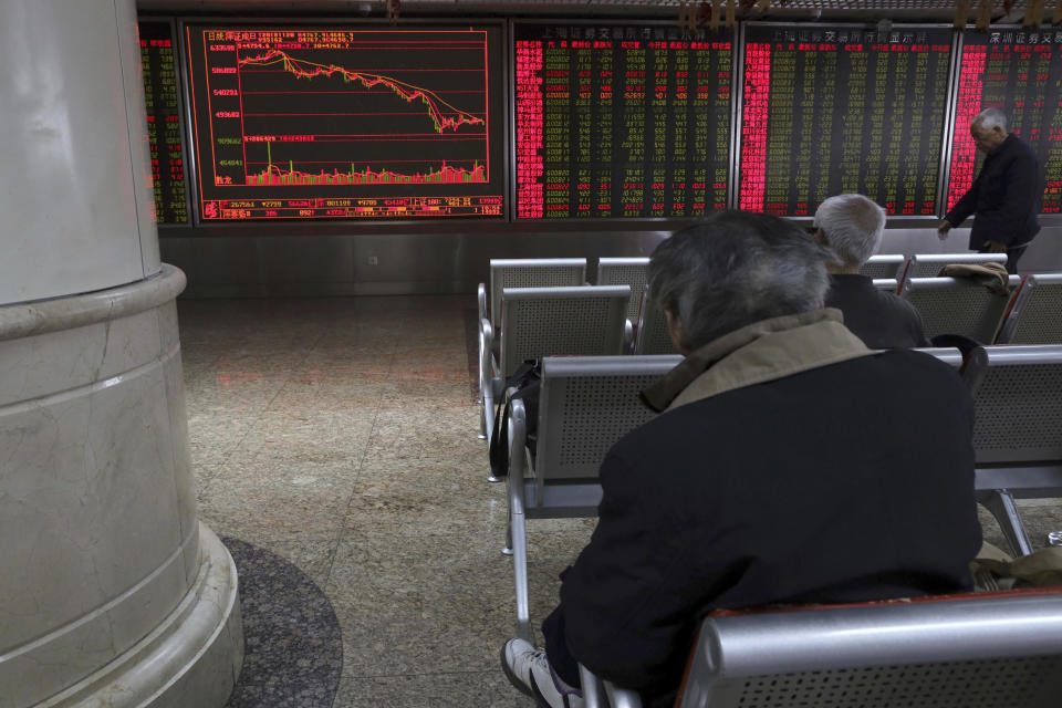 Investors monitor stock prices at a brokerage in Beijing Tuesday, Nov. 20, 2018. Asian stocks slid Tuesday after tech losses dragged down Wall Street and Nissan's chairman was arrested on charges of financial misconduct. (AP Photo/Ng Han Guan)