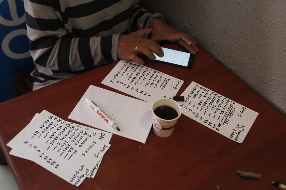 Pharmacist Bikram Bhadel calculates the number of food orders to deliver to Teaching Hospital in Kathmandu, Nepal, Monday, Aug. 31, 2020. At one of the largest hospitals in Nepal, a pharmacist and taxi driver have teamed up to feed COVID-19 patients, doctors, nurses and health workers. Due to lockdowns, the cafeteria and nearby cafes have closed, leaving more than 200 staffers, patients and their families without food. The two friends have taken their own money and donations and put it to use buying groceries, renting a kitchen and paying helpers to provide the meals. (AP Photo/Niranjan Shrestha)