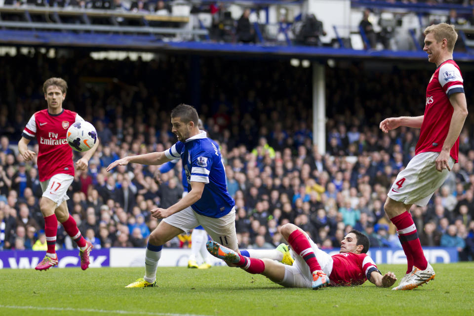 Everton's Kevin Mirallas, centre left, scores against Arsenal despite the attentions of Mikel Arteta, bottom right, during their English Premier League soccer match at Goodison Park Stadium, Liverpool, England, Sunday April 6, 2014. (AP Photo/Jon Super)