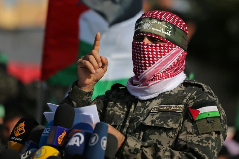 /Abu Ubaida, the spokesman of the Izz el-Deen al-Qassam Brigades, gestures as he speaks during an anti-Israel military show in the southern Gaza Strip