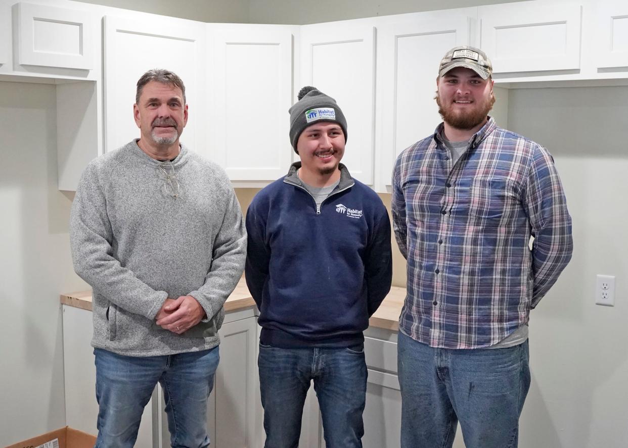 Habitat for Humanity of Lenawee County Construction Manager Doug Straub, left, stands alongside construction workers Justin Rincon and Jackson Marsh Nov. 27, 2023, during Habitat's latest ribbon cutting and home dedication ceremony in Adrian.