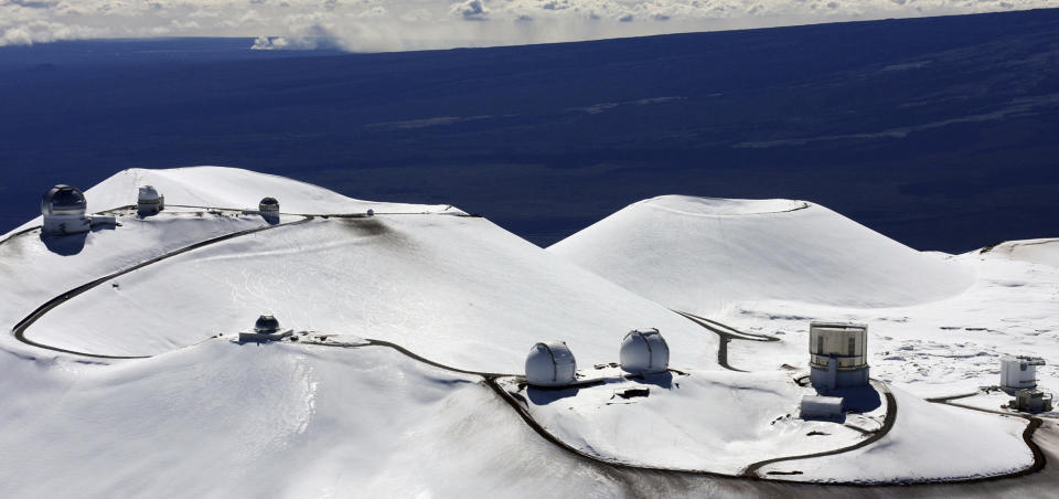 FILE - This Jan. 6, 2009, file photo shows astronomy observatories atop Mauna Kea, a dormant volcano on Hawaii's Big Island where some Native Hawaiians have been peacefully protesting the construction of what would be one of the world's largest telescopes. Astronomers across 11 observatories on Hawaii’s tallest mountain have cancelled more than 2,000 hours of telescope viewing over the past four weeks because the protest blocked a road to the summit. Astronomers said Friday, Aug. 9, 2019, they will attempt to resume observations but in some cases won’t be able to make up the missed research. (AP Photo/Tim Wright, File)