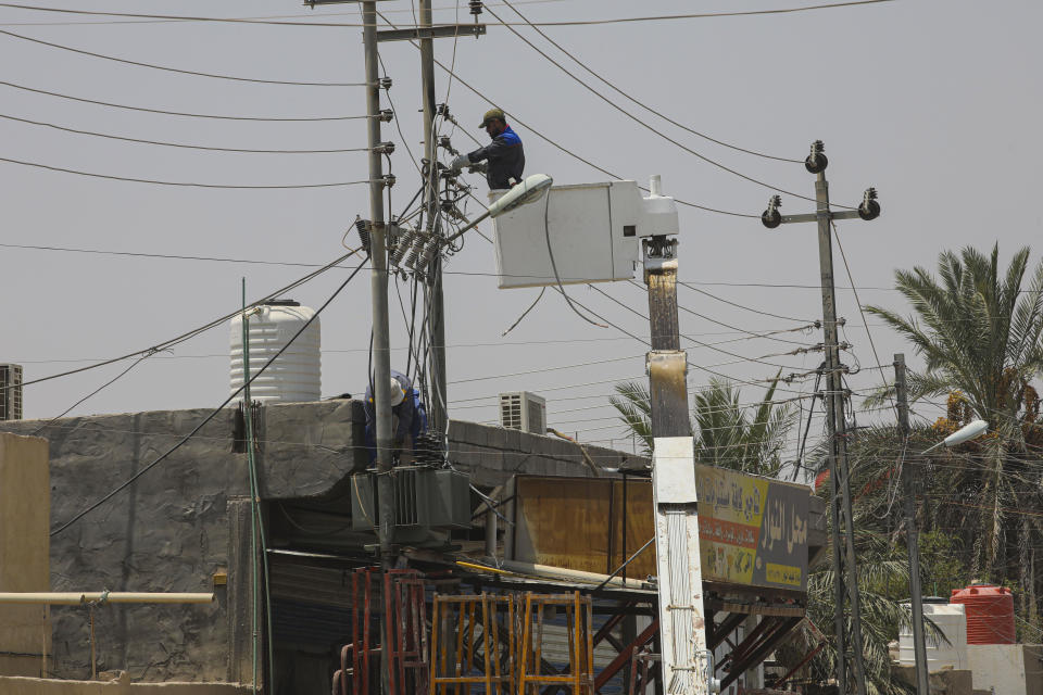 Ministry of Electricity workers are trying to maintain the electricity transmission network in Basra, Iraq, Thursday, July. 30, 2020. As temperatures soar to record levels this summer, Iraq's power supply falls short of demand again, providing a spark for renewed anti-government protests. Amid a nationwide virus lockdown, homes are without electricity for hours in the blistering heat. (AP Photo/Nabil al-Jurani)