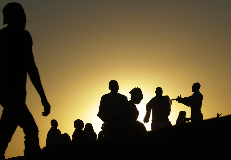 Zimbabweans sit and pray on top of a large rock on the outskirts of Harare, Zimbabwe, Sunday, Sept. 8, 2019. Former president Robert Mugabe, who enjoyed strong backing from Zimbabwe's people after taking over in 1980 but whose support waned following decades of repression, economic mismanagement and allegations of election-rigging, is expected to be buried next Sunday, state media reported. (AP Photo/Themba Hadebe)
