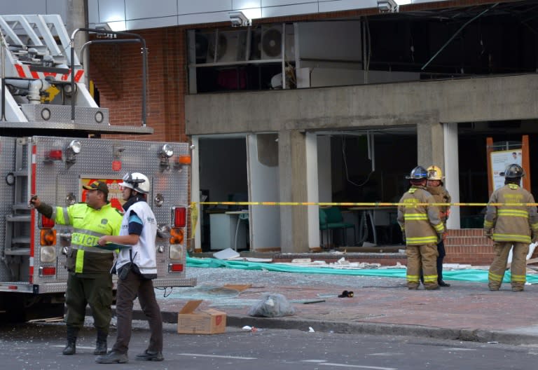 Colombian police officers check the site of an explosion in the financial heart of Bogota on July 2, 2015