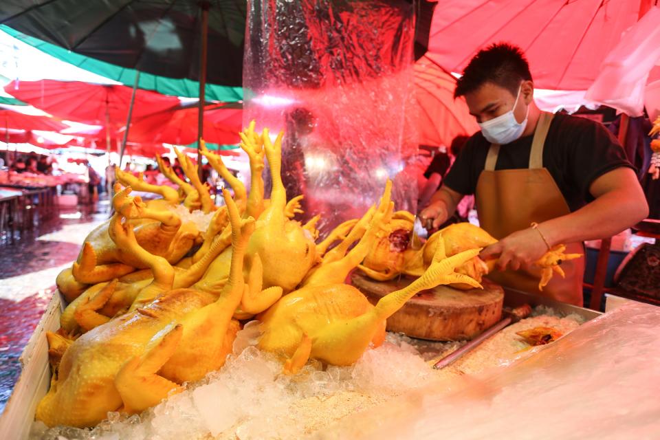 A worker prepares chicken meat for sell at Khlong Toei market in Bangkok. The Department of Livestock Development is keeping a close watch on the spread of the H5N6 avian influenza after the World Health Organization has warned of a possible outbreak following recent infection cases in China.