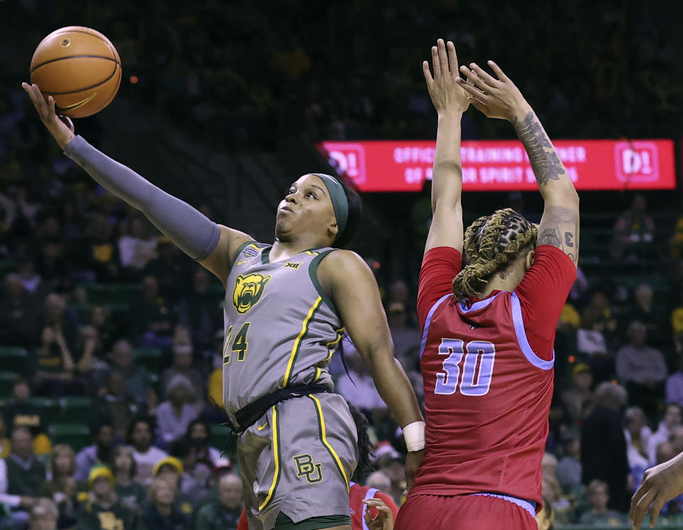 Baylor guard Sarah Andrews (24) scores past Delaware State forward McKenzie Stewart during the second half of an NCAA college basketball game Thursday, Dec. 14, 2023, in Waco, Texas. (Jerry Larson/Waco Tribune-Herald via AP)