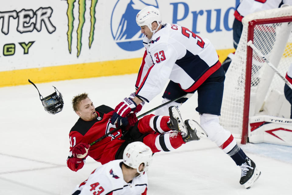 Washington Capitals' Zdeno Chara (33) checks New Jersey Devils' Andreas Johnsson (11) during the first period of an NHL hockey game Sunday, April 4, 2021, in Newark, N.J. (AP Photo/Frank Franklin II)