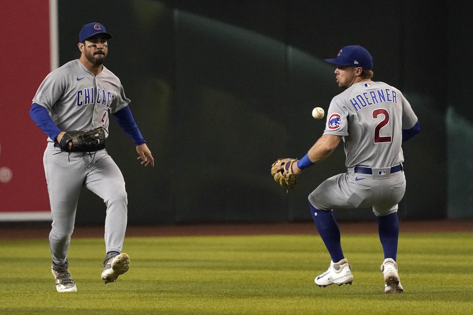 Chicago Cubs second baseman Nico Hoerner (2) misses a fly ball off the bat of Arizona Diamondbacks' Lourdes Gurriel Jr., as centerfielder Mike Tauchman backs him up during the first inning of a baseball game, Sunday, Sept. 17, 2023, in Phoenix. (AP Photo/Darryl Webb)