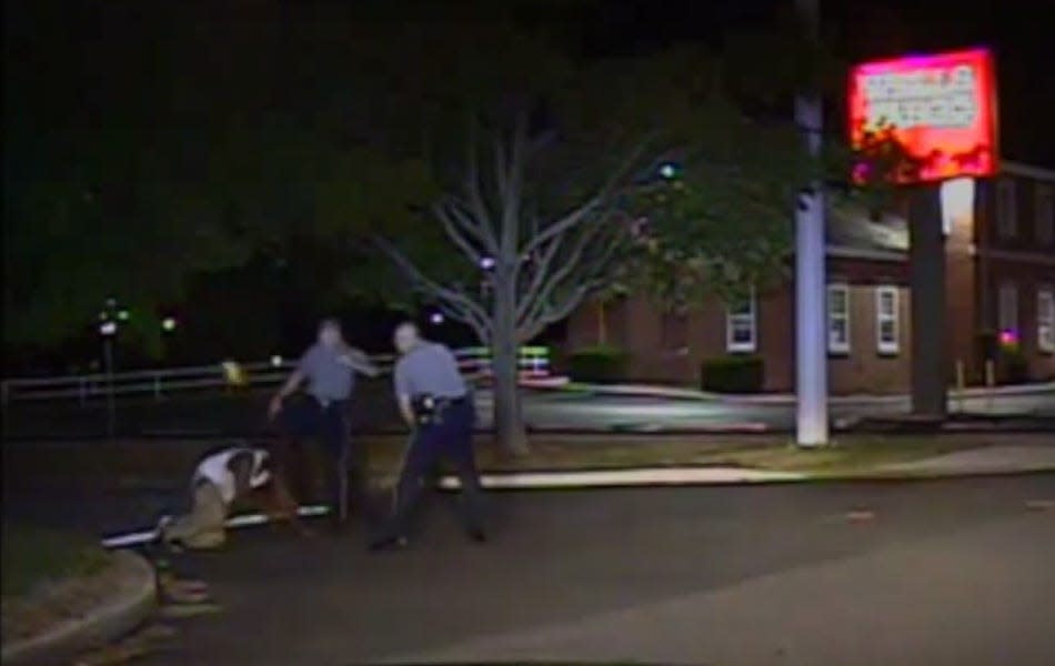 In this image taken from footage filmed by a Dover Police dashboard camera, Dover Police Cpl. Thomas Webster IV (center) kicks Lateef Dickerson on Aug. 24, 2013, at a gas station on U.S. 13. The image was enhanced by The News Journal. It’s unclear whether two 12-member grand juries convened in the case saw the video.