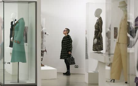 A visitor looks at clothing on display in the "Women Fashion Power exhibition at the Design Museum in London November 4, 2014. REUTERS/Suzanne Plunkett