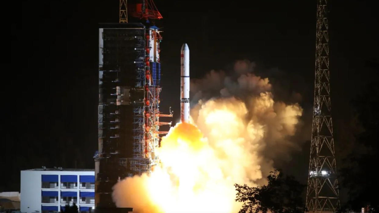  A white rocket launches at night. 